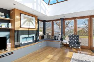 a living room with a fireplace and a chair at Oaktree Lodge - Luxury Cottage, Hot Tub, Sea Views in Saundersfoot +43 photos