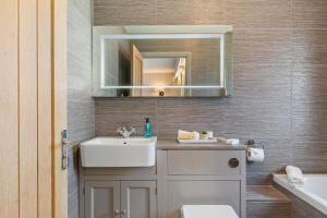 a bathroom with a sink and a mirror at Oaktree Lodge - Luxury Cottage, Hot Tub, Sea Views in Saundersfoot