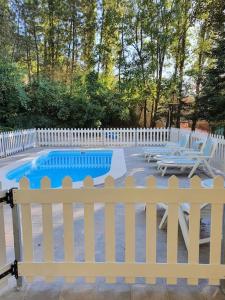 a white fence with a pool and a table and chairs at CASA CAÑADA DEL PUERTO in Cazorla