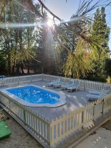 a swimming pool with chairs and a white fence at CASA CAÑADA DEL PUERTO in Cazorla