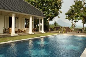 a swimming pool in front of a house at Plataran Borobudur in Borobudur