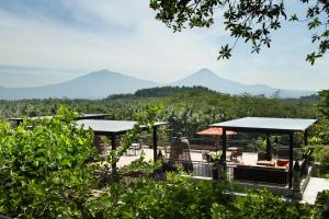 einen Blick auf die Berge von einem Resort mit Bergen im Hintergrund in der Unterkunft Plataran Borobudur in Borobudur