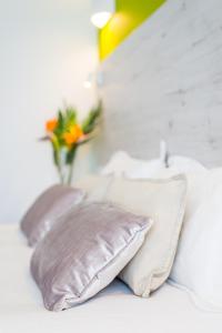 a bed with two pillows and a vase of flowers on it at Dunas Club - Hotel & Apartamentos in Corralejo