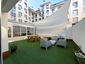 um pátio exterior com uma mesa e cadeiras e um edifício em Amplio y moderno piso de 4 habitaciones y terraza em Pontevedra