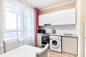 een keuken met een wasmachine en een wastafel bij Квартира в центре города 7-й этаж in Taldykolʼ