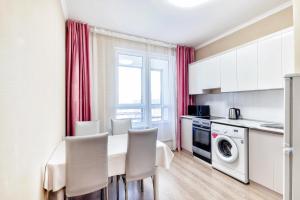 een keuken met een tafel en stoelen in een kamer bij Квартира в центре города 7-й этаж in Taldykolʼ