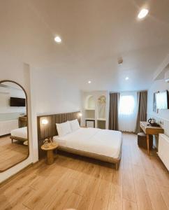 1 dormitorio con cama blanca y espejo en Meshk Airport Hotel en Arnavutköy