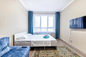 een kleine slaapkamer met een bed en een raam bij Квартира в центре города 7-й этаж in Taldykolʼ