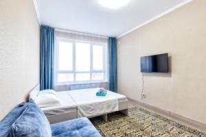 een hotelkamer met een bed en een raam bij Квартира в центре города 7-й этаж in Taldykolʼ +8 foto's