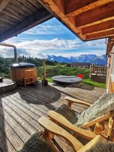 una terraza de madera con bañera de hidromasaje y banco en Hamilton Lodge & Spa en Belalp