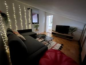 Piko's apartments في إيزولا: غرفة معيشة مع أريكة وأضواء على الحائط