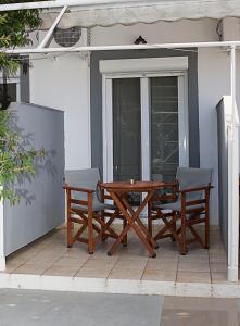 una mesa de madera y sillas en un patio en La Pensione Skiathos en Skiathos