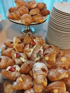 a pile of pastries on a table next to plates at SI Rimini Hotel in Rimini