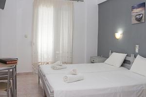 1 dormitorio con 2 camas y toallas. en La Pensione Skiathos en Skiathos