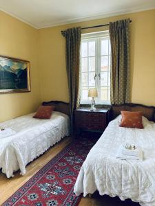 a bedroom with two beds and a window at Köpmansgården Bed & Breakfast in Vellinge