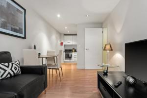 a living room with a black couch and a table at One Bed Serviced Apartment near Blackfriars in London