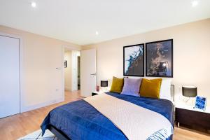 a bedroom with a bed with blue and yellow pillows at One Bed Serviced Apartment near Blackfriars in London