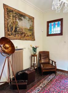 a living room with a chair and a painting on the wall at Köpmansgården Bed & Breakfast in Vellinge