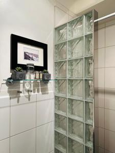 a glass block cabinet in a bathroom with a shelf at Köpmansgården Bed & Breakfast in Vellinge