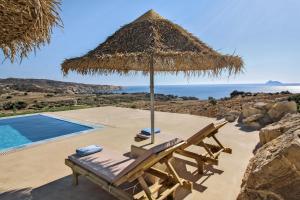 a straw umbrella and a chair next to a swimming pool at Beachfront villa Komos with heated pool in Kalamaki