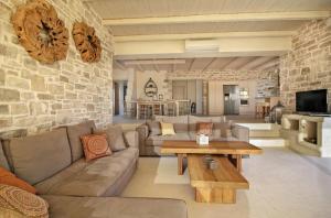 a living room with a couch and a table at Beachfront villa Komos with heated pool in Kalamaki