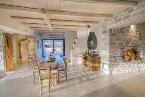 a dining room with a stone wall and a table and chairs at Beachfront villa Komos with heated pool in Kalamaki