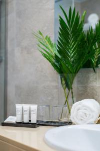 a bathroom counter with three cups and a towel at Dunas Club - Hotel & Apartamentos in Corralejo