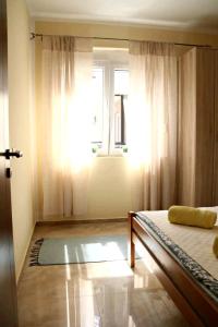 1 dormitorio con cama y ventana en Aurora Apartments, en Igalo