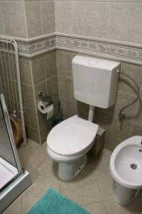 y baño con aseo blanco y lavamanos. en Aurora Apartments en Igalo