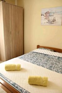 1 dormitorio con 1 cama con 2 toallas amarillas en Aurora Apartments, en Igalo