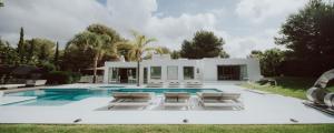 a villa with a swimming pool and lounge chairs at Can Rocas in Sant Josep de sa Talaia
