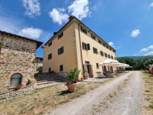 a large stone building with a dirt road in front of it at Hotel Relais Palazzo di Luglio in Sansepolcro