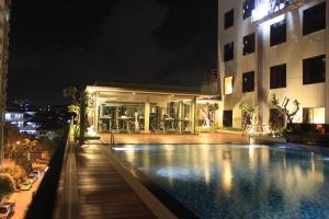 a swimming pool in front of a building at night at I Hotel Baloi Batam in Nagoya