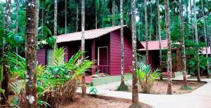 a small red house in the middle of a forest at Lazo Areca Resort , Coorg in Madikeri