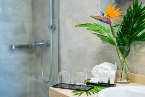 a bathroom with a vase with a flower and glasses at Dunas Club - Hotel & Apartamentos in Corralejo