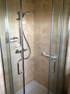 a shower with a glass door in a bathroom at Coastal bungalow, sleeps 5 and ideal for walkers in Amlwch