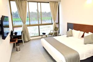a bedroom with a bed and a large window at Clarks Inn Express, KRS road-Mandya, Mysore in Mysore