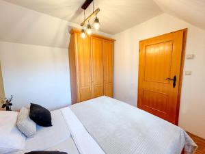um quarto com uma cama e uma porta de madeira em Miadora apartments - Apartma Prekmurska hiška em Moravske-Toplice