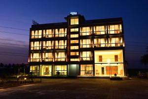 a large building with many windows at night at Clarks Inn Express, KRS road-Mandya, Mysore in Mysore