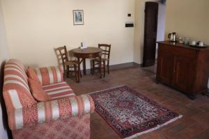 ein Wohnzimmer mit einem Sofa und einem Tisch in der Unterkunft Hotel Relais Palazzo di Luglio in Sansepolcro