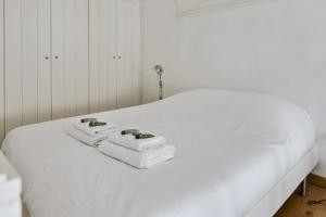ein weißes Bett mit zwei Handtüchern darüber in der Unterkunft Large atypical flat at the heart of Montpellier - Welkeys in Montpellier
