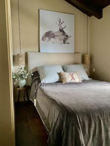 Schlafzimmer mit einem Bett mit einem Hirschbild an der Wand in der Unterkunft Xalet Montana in Ur