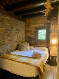 a bedroom with a bed in a stone wall at Xalet Montana in Ur