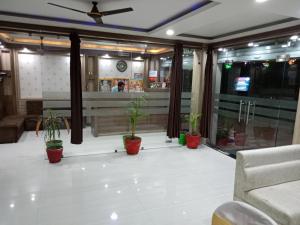 a restaurant with potted plants on the floor at HOTEL R K PALACE in Bhopal