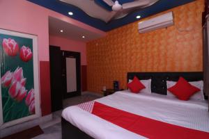 - une chambre avec un grand lit et des oreillers rouges dans l'établissement OYO Hotel Jagannath International Near Kolkata Airport, à Gauripur