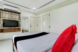 1 Schlafzimmer mit einem weißen Bett und einem TV in der Unterkunft Super Capital O Vrisha Inn in Jalāripeta