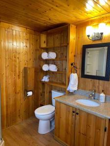 een houten badkamer met een toilet en een wastafel bij Cozy Grand Bend Cottage with Bunkie in Grand Bend