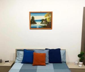 a bed with blue and orange pillows in a room at B&B Nonno Walter in Torre del Greco