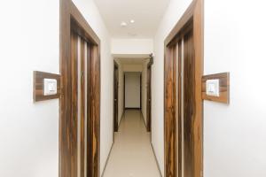 a corridor with wooden doors and a hallway with at Hotel O Gems in Turambhe