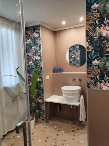 a bathroom with a sink and a shower with flowers at CasaOtto in Turin